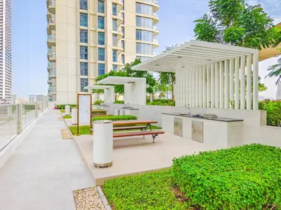 a park with a bench and a building at Sea-Front Unique Retreat With Balcony in Marina in Dubai