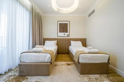 two beds in a hotel room with a chandelier at SettlerHomes - Sparkle Tower 2 With Marina & Sea View in Dubai