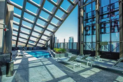 a building with a pool and chairs and a building at SettlerHomes - Sparkle Tower 2 With Marina & Sea View in Dubai