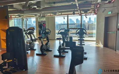 a gym with treadmills and elliptical machines at 2BR Apt next to DubaiMall, pool view of Burj Khalifa - Downtown Views ll in Dubai