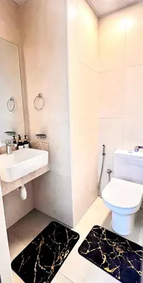 a white bathroom with a sink and a toilet at Stylish & Roomy 1BR in the Heart of the City in Dubai