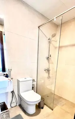 a bathroom with a toilet and a glass shower at Stylish & Roomy 1BR in the Heart of the City in Dubai