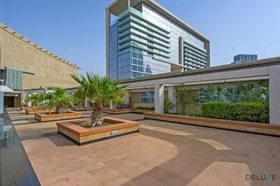 a courtyard with palm trees and a tall building at Grand Studio at Sky Gardens DIFC by Deluxe Holiday Homes in Dubai