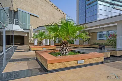 a courtyard with palm trees and a building at Grand Studio at Sky Gardens DIFC by Deluxe Holiday Homes in Dubai