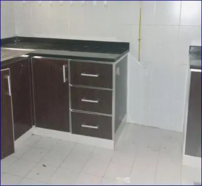 a kitchen with brown cabinets and a counter top at Studio Flat in AWS only Bachelor no family no children in Dubai