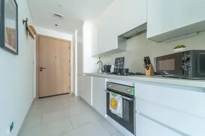 a kitchen with a stove and a microwave at Frank Porter - Marquise Square Tower in Dubai