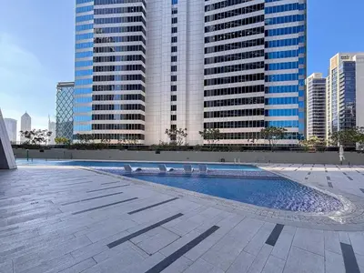a swimming pool in a city with tall buildings at Frank Porter - Marquise Square Tower in Dubai