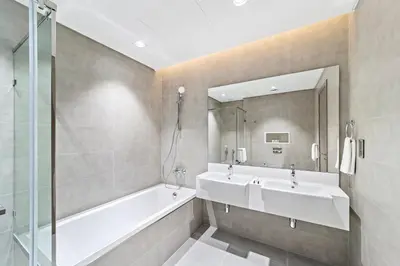 a bathroom with two sinks and a tub and a mirror at ALiving Classy 2BR I Lagoons View I District One Residence 7 in Dubai
