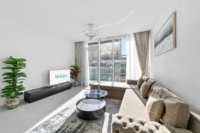 a living room with a couch and a tv at ALiving Classy 2BR I Lagoons View I District One Residence 7 in Dubai