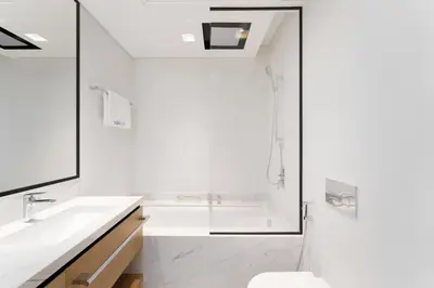 a white bathroom with a tub and a sink at Luxe 1-Bedroom Elegance in Palace Residences in Dubai