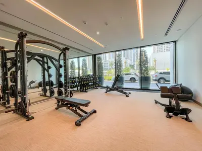 a gym with a large mirror and several tread machines at Luxe 1-Bedroom Elegance in Palace Residences in Dubai
