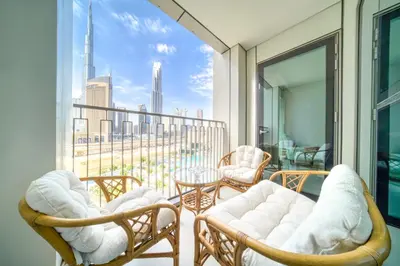 a balcony with chairs and tables and a view of the city at Downtown - 2BR Apartment with Burj Khalifa View in Dubai