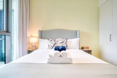 a bedroom with a bed with towels on it at Downtown - 2BR Apartment with Burj Khalifa View in Dubai