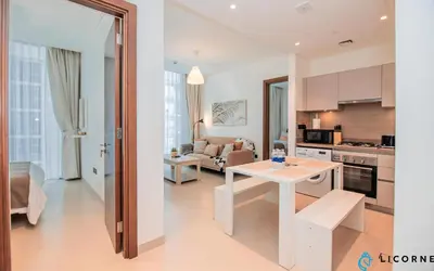 a kitchen and living room with a white table in a room at Inviting 2BR Apartment - Only 10 Mins to Downtown - Sobha Creek Vista Reserve in Dubai