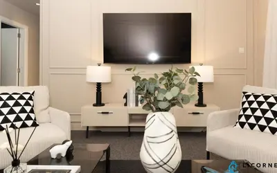 a living room with a large white vase with flowers at Prime Spacious 2 BR Apt, Burj Khalifa & Canal View - Scala Tower in Dubai