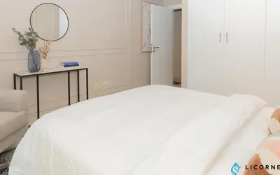 a white bed in a room with a mirror at Prime Spacious 2 BR Apt, Burj Khalifa & Canal View - Scala Tower in Dubai