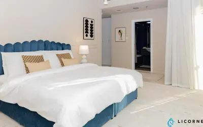 a bedroom with a large bed with a blue headboard at Prime Spacious 2 BR Apt, Burj Khalifa & Canal View - Scala Tower in Dubai