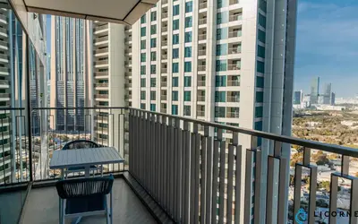 a balcony with a table and a view of a city at Brand New Modern 2BR Retreat, Walk to Dubai Mall - Downtown Views ll in Dubai