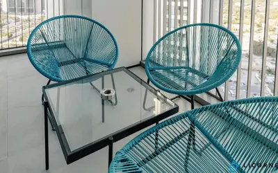 three chairs and a glass table in a room at Brand New Modern 2BR Retreat, Walk to Dubai Mall - Downtown Views ll in Dubai