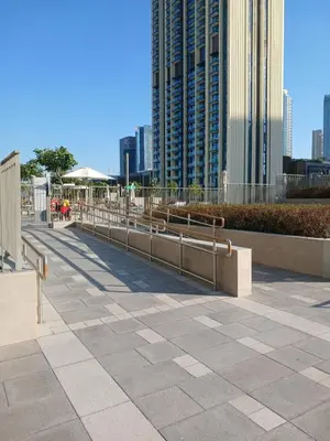 a row of benches in a city with tall buildings at Brand New Modern 2BR Retreat, Walk to Dubai Mall - Downtown Views ll in Dubai
