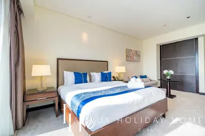 a bedroom with a large bed with blue pillows at LUX The JW Marina Studio in Dubai