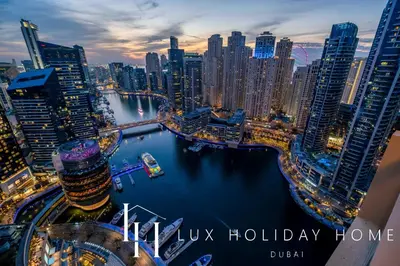 a view of a city at night with the words happy holiday home at LUX The JW Marina Studio in Dubai