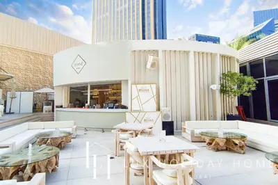 a patio with tables and couches on a building at LUX The JW Marina Studio in Dubai