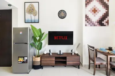 a kitchen with a refrigerator and a wooden table at Modern Sports City Studio Pool, Gym & Stadium in Dubai