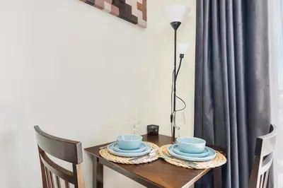 a table with two cups and plates on it at Modern Sports City Studio Pool, Gym & Stadium in Dubai