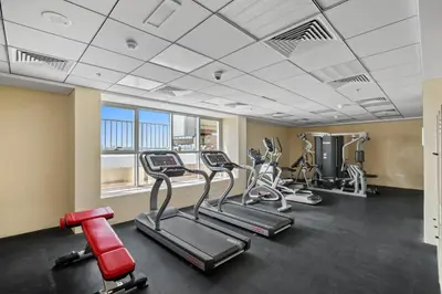 a gym with treadmills and cardio equipment in a building at Modern Sports City Studio Pool, Gym & Stadium in Dubai