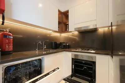 a kitchen with white cabinets and an oven at 1BR Gem with Stunning Marina Views, Close to Metro in Dubai