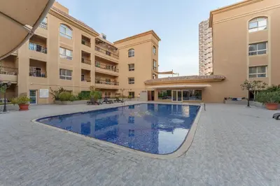 a swimming pool in the courtyard of a building at Extraordinary Loft Living in JVC by Suiteable in Dubai