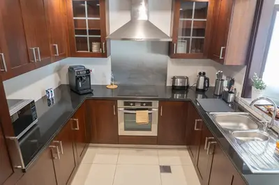 a kitchen with a sink and a stove top oven at Downtown Oasis, Burj Khalifa Views, Luxury Amenities in Dubai