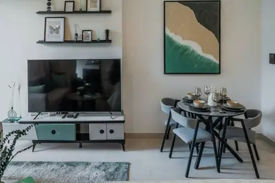 a dining room with a table and chairs and a tv at Clever Guest 014 Binghatti Canal in Dubai