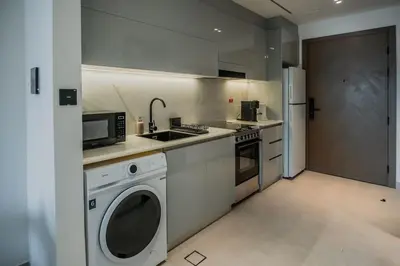 a kitchen with a sink and a washing machine at Clever Guest 014 Binghatti Canal in Dubai