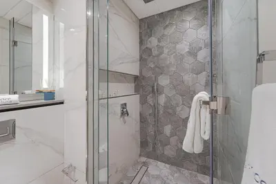 a bathroom with a shower with a glass door at Ravishing Studio at MAG 318, Business Bay in Dubai