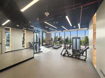 a gym with cardio equipment and large windows at Luxurious Studio in Westwood by Imtiaz - Al Furjan in Dubai