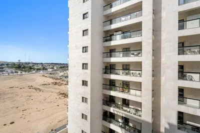 an apartment building with a beach in the background at Luxurious Studio in Westwood by Imtiaz - Al Furjan in Dubai
