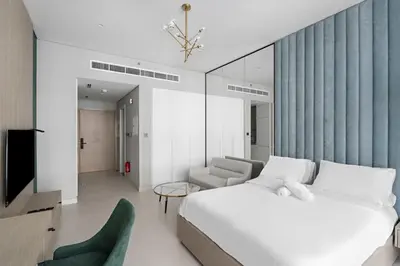 a bedroom with a bed and a couch and a tv at Luxurious Studio in Westwood by Imtiaz - Al Furjan in Dubai