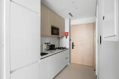a kitchen with white cabinets and a sliding door at Luxurious Studio in Westwood by Imtiaz - Al Furjan in Dubai