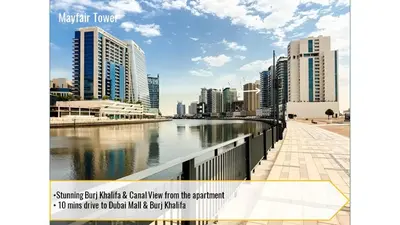 a city with tall buildings next to a river at SkylineOasis1BR apt with BurjKhalifa & CanalView in Dubai