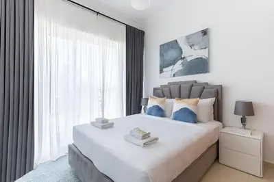 a bedroom with a large bed with a large window at SkylineOasis1BR apt with BurjKhalifa & CanalView in Dubai