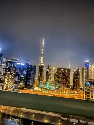 a view of a city skyline at night at SkylineOasis1BR apt with BurjKhalifa & CanalView in Dubai
