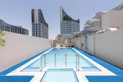 a swimming pool on the rooftop of a building with skyscrapers at SkylineOasis1BR apt with BurjKhalifa & CanalView in Dubai