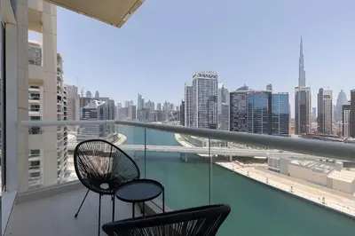 two chairs on a balcony with a view of the city at SkylineOasis1BR apt with BurjKhalifa & CanalView in Dubai