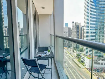 a balcony with two chairs and a table with a view at HiGuests - City Elegance 1BR in The Sterling by Omniyat in Dubai