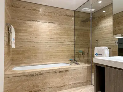 a bathroom with a tub and a glass shower at HiGuests - City Elegance 1BR in The Sterling by Omniyat in Dubai