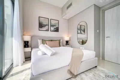 a bedroom with a large white bed and a mirror at Canal Views! Promotional Rate on Lovely 1BR by Deluxe Holiday Homes in Dubai