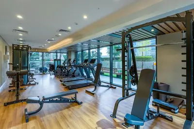a gym with a bunch of treadmills and machines at Canal Views! Promotional Rate on Lovely 1BR by Deluxe Holiday Homes in Dubai