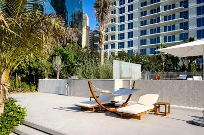 a couple of chairs and an umbrella on a patio at Luxury apartments at La Vie in Dubai